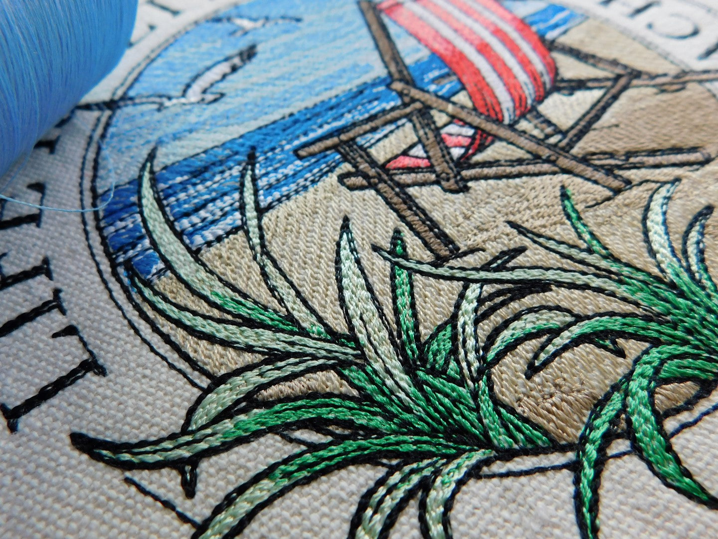 Embroidery of a beach scene with a red striped beach chair, grass, and text on 100% cotton tote bag.